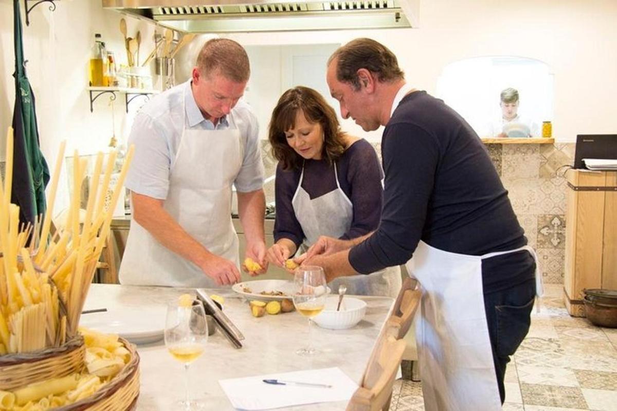 un gruppo di tre persone in cucina che preparano il cibo