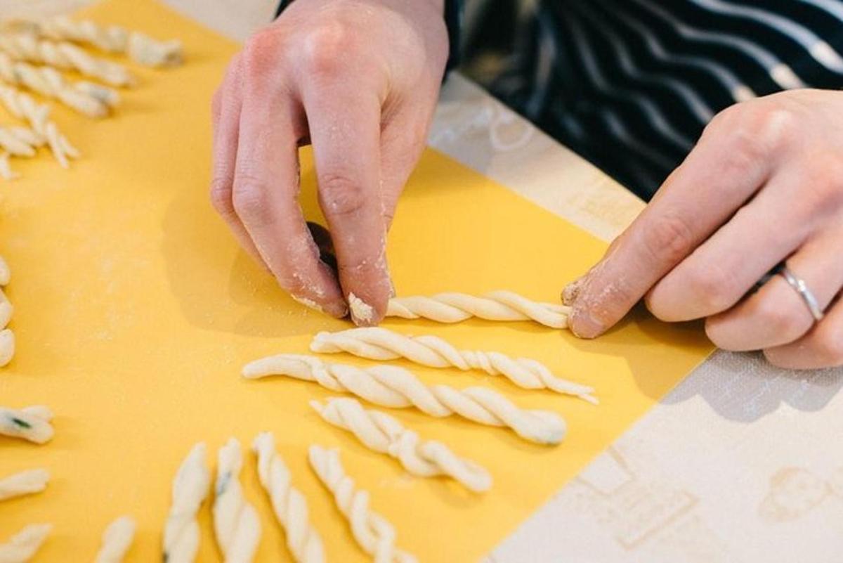 a person is making pasta on a cutting board