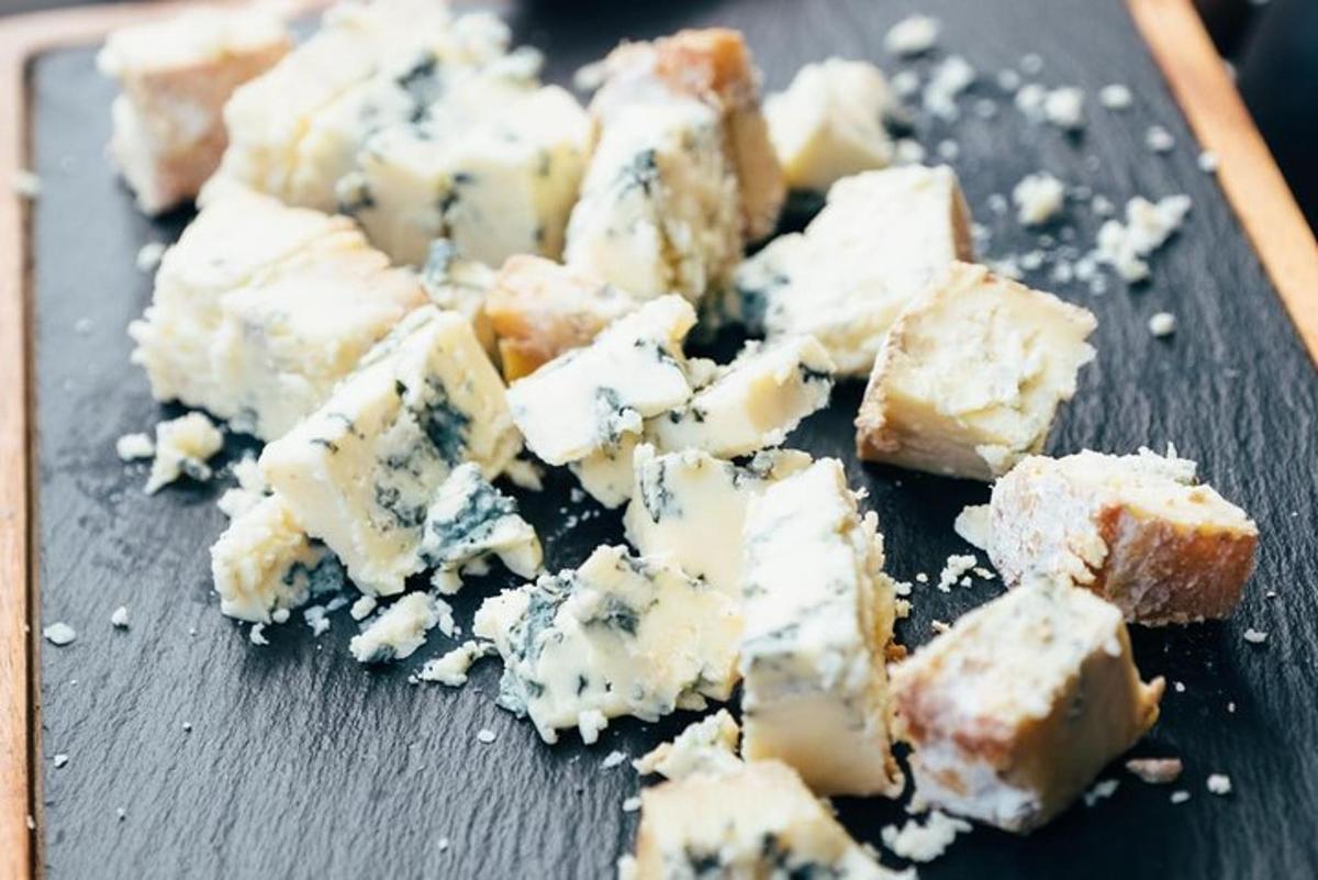 a pile of cheese on a black cutting board