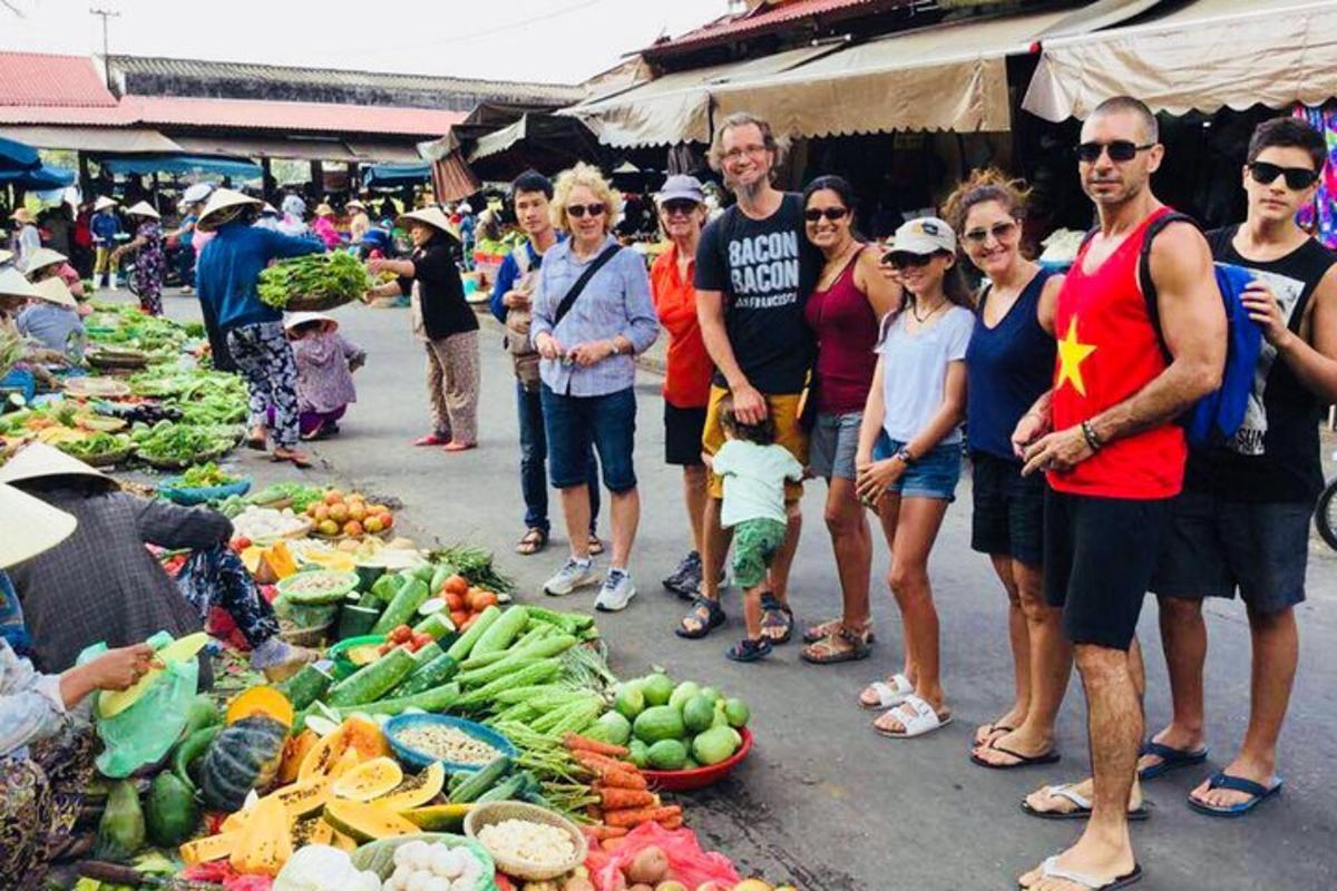 un grup de persones al voltant d'un mercat amb verdures