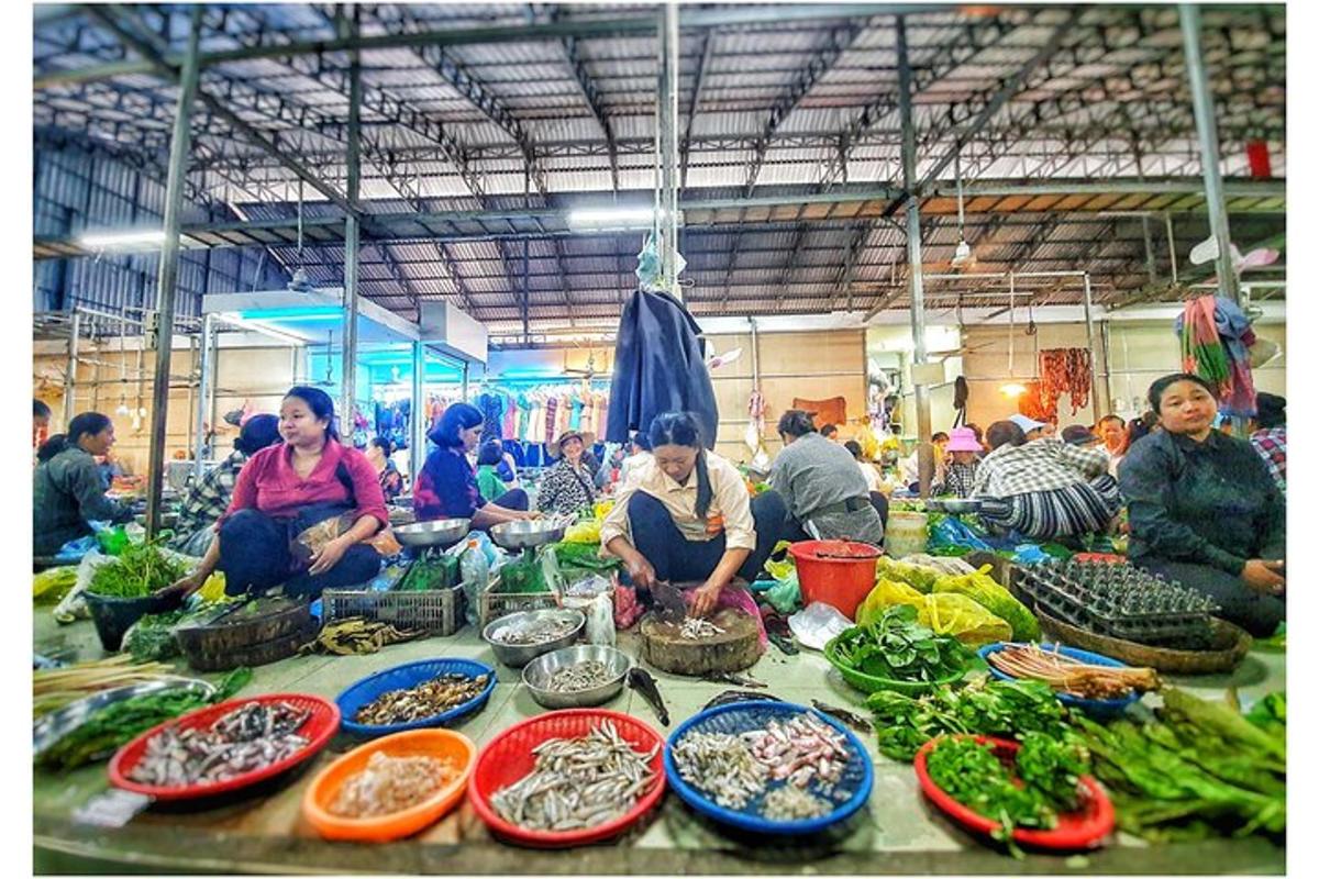 um grupo de pessoas sentadas em um mercado com vegetais