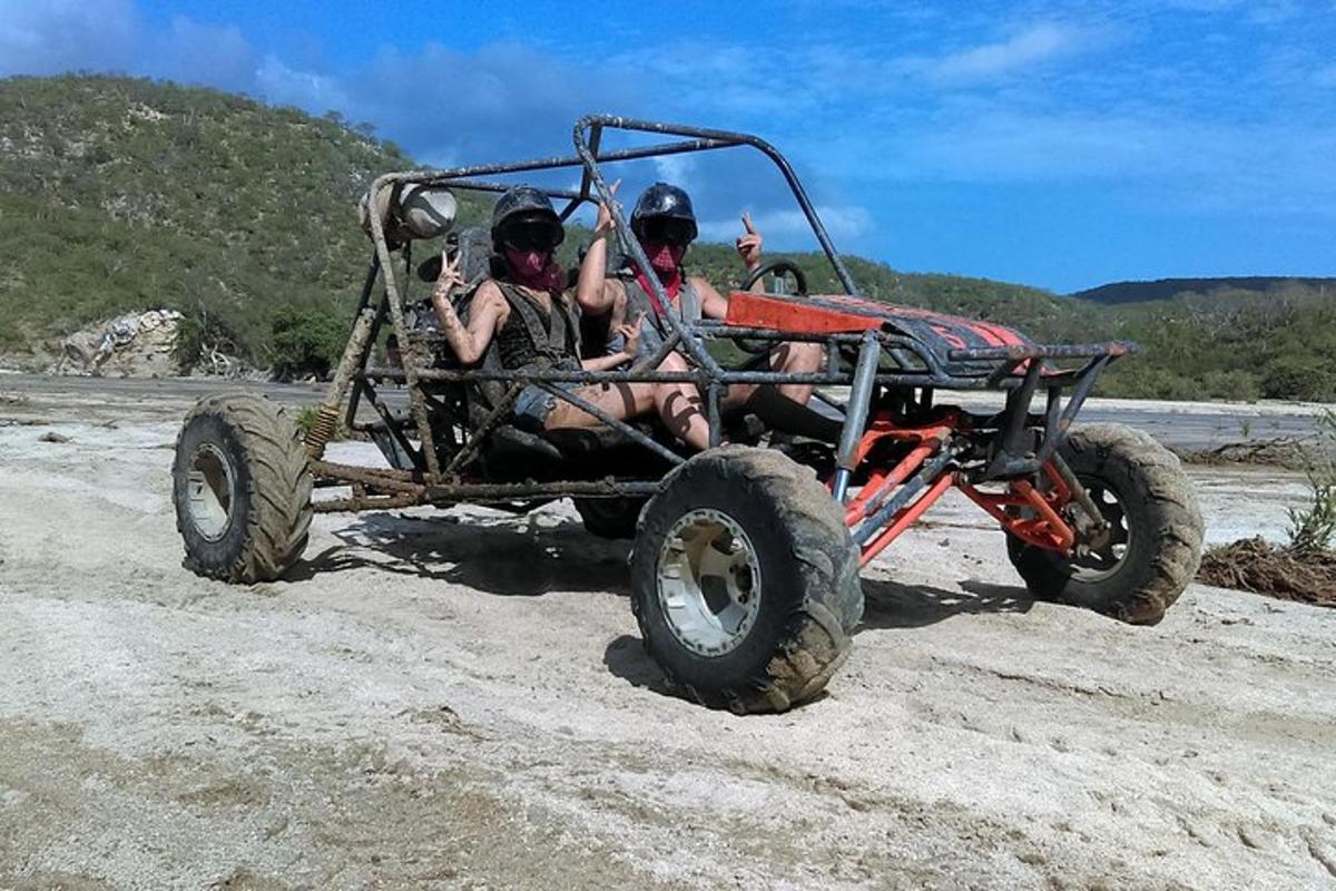 dua orang menaiki kereta empat roda di pantai