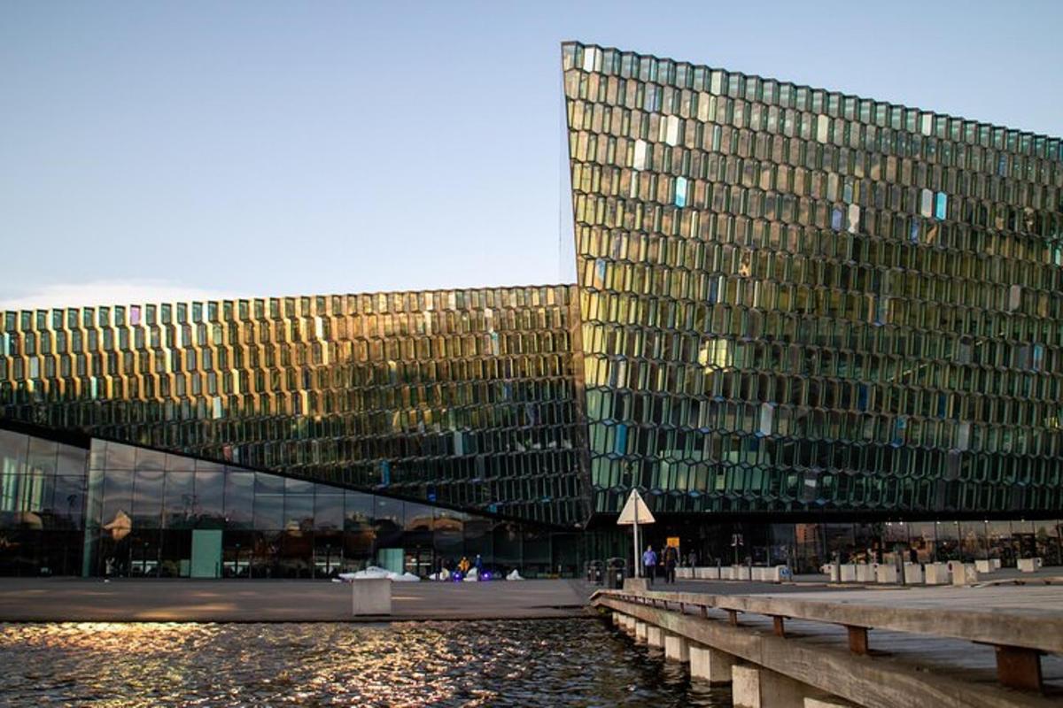 Un gran edificio de cristal al lado de un cuerpo de agua.