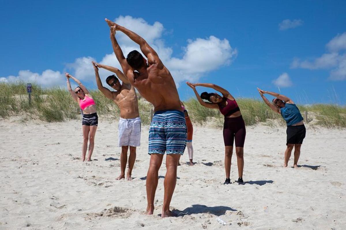 a group of people doing yoga on the beach