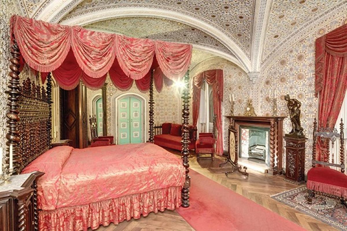 ein Schlafzimmer mit einem Bett mit einem roten Baldachin