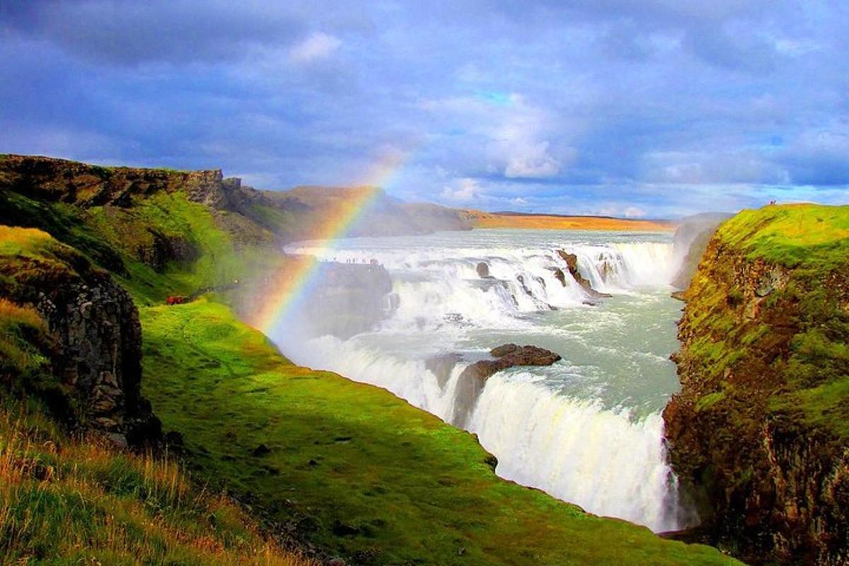 Un arcoíris sobre una cascada con un río.