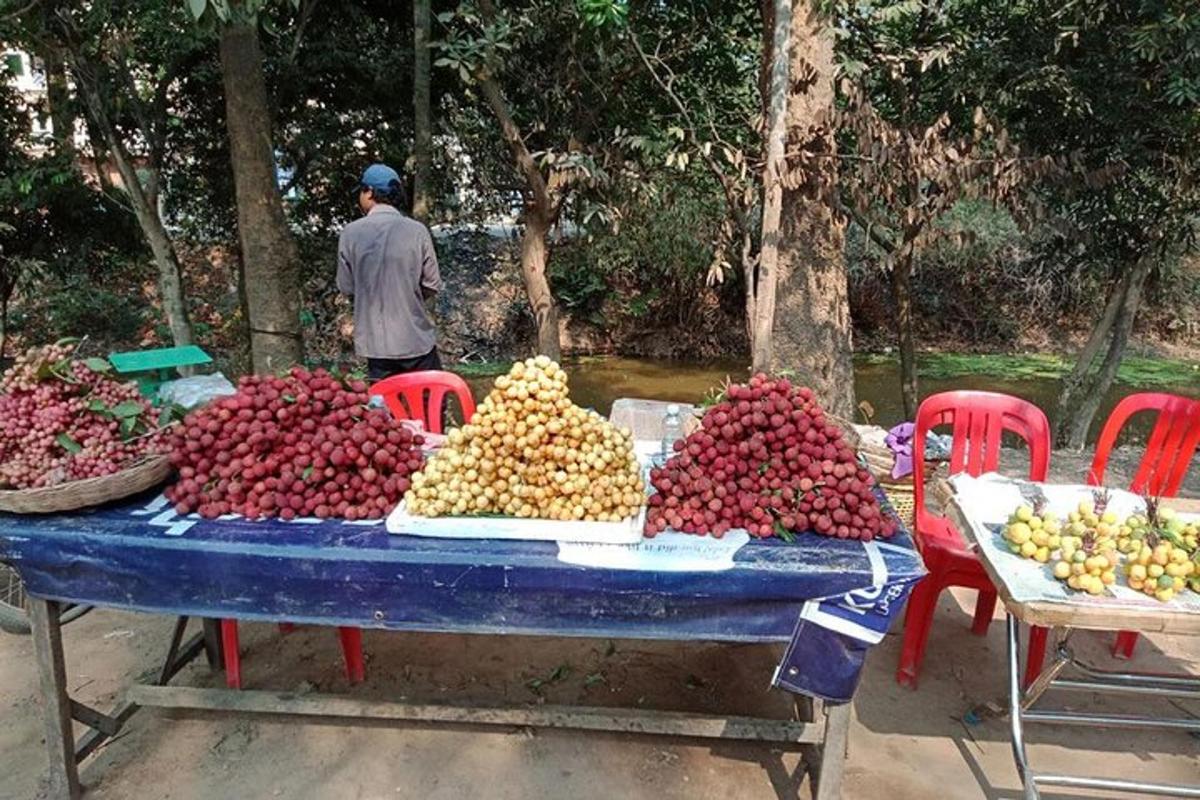 sebuah meja penuh dengan buah-buahan dengan seorang lelaki berdiri di belakangnya