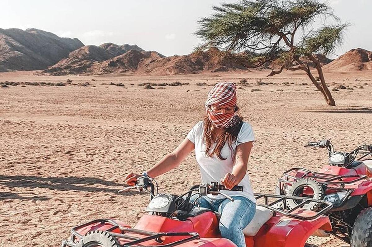 een vrouw die op een motorfiets in de woestijn zit