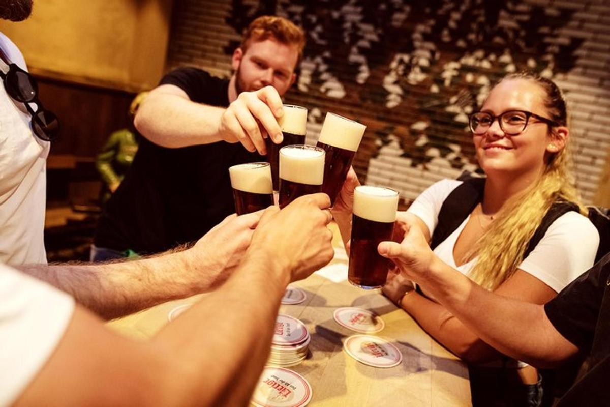 skupina ljudi, ki sedijo okoli mize in pijejo pivo