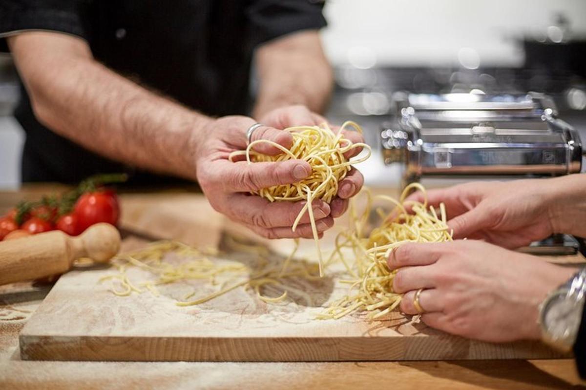 two people are preparing noodles on a cutting board