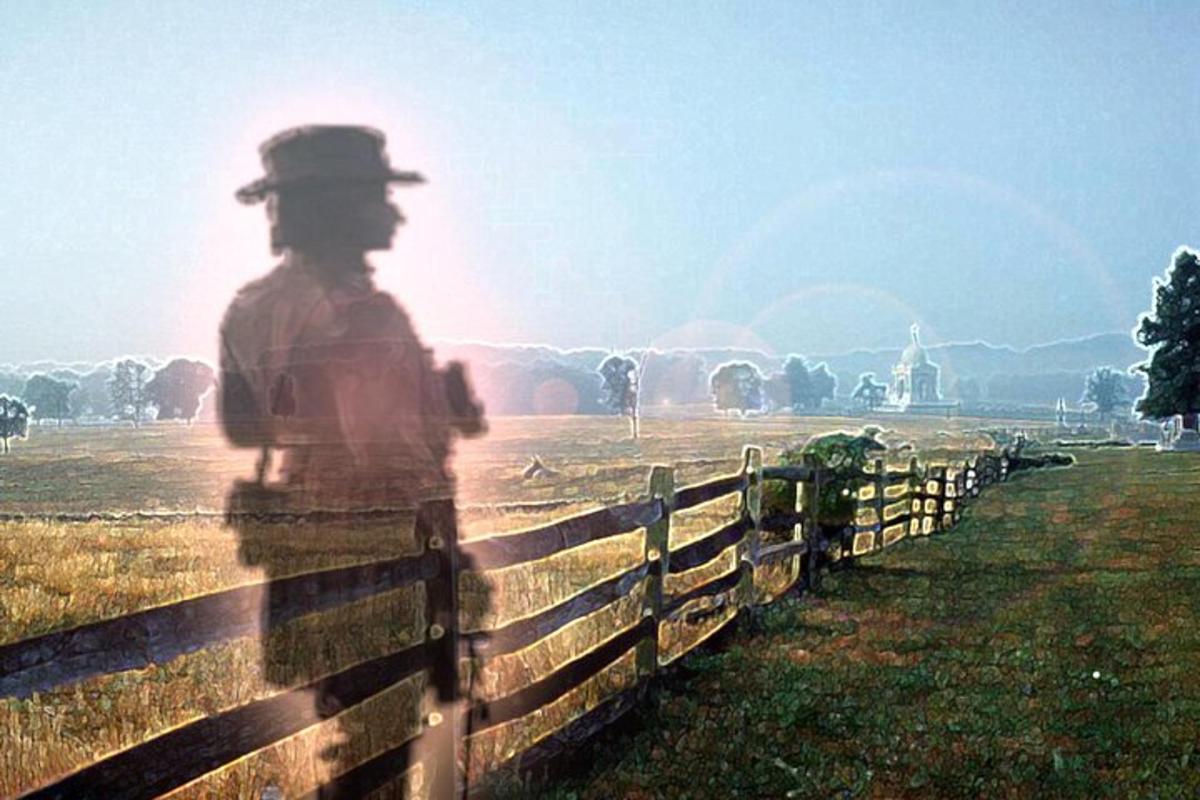 a man standing behind a fence in a field