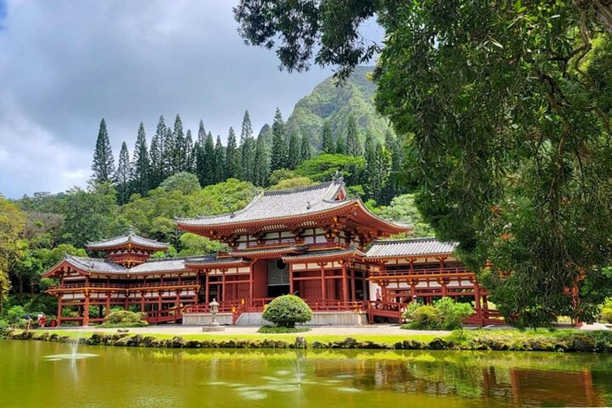 Un gran edificio junto a un lago frente a una montaña.
