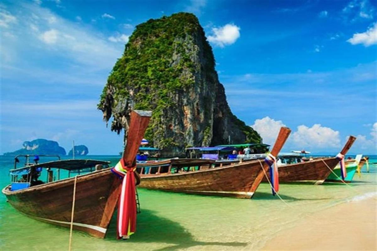 dois barcos em uma praia com uma montanha ao fundo