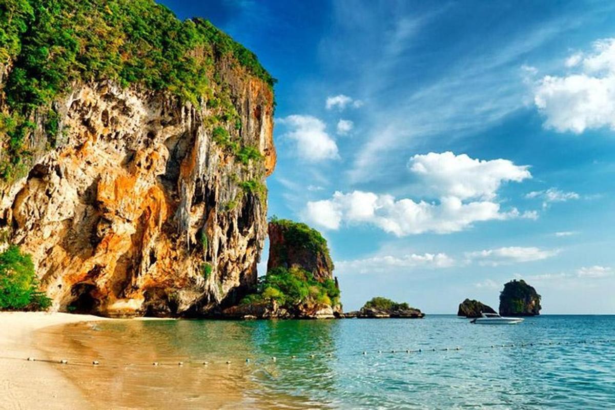 uma praia com uma montanha e a água e um barco