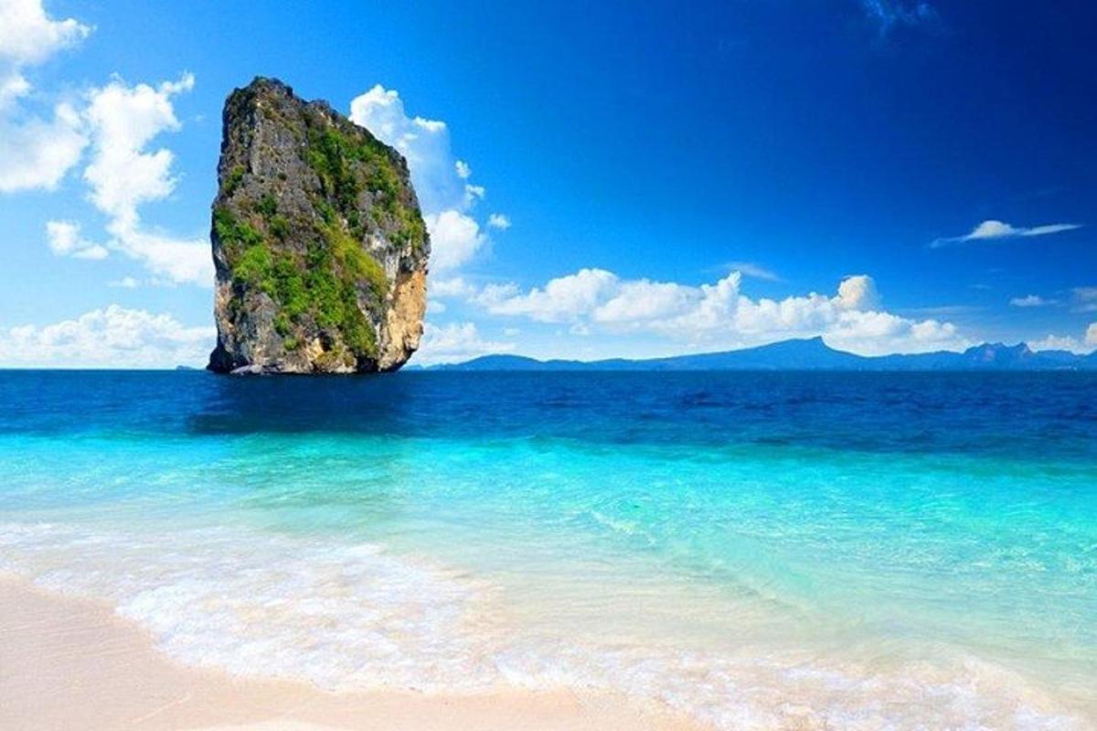 uma grande rocha na água em uma praia