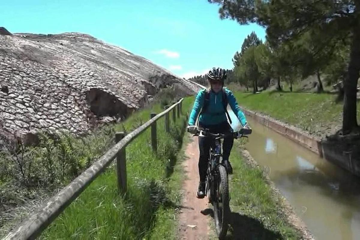 un homme faisant du vélo sur un chemin près d'une rivière