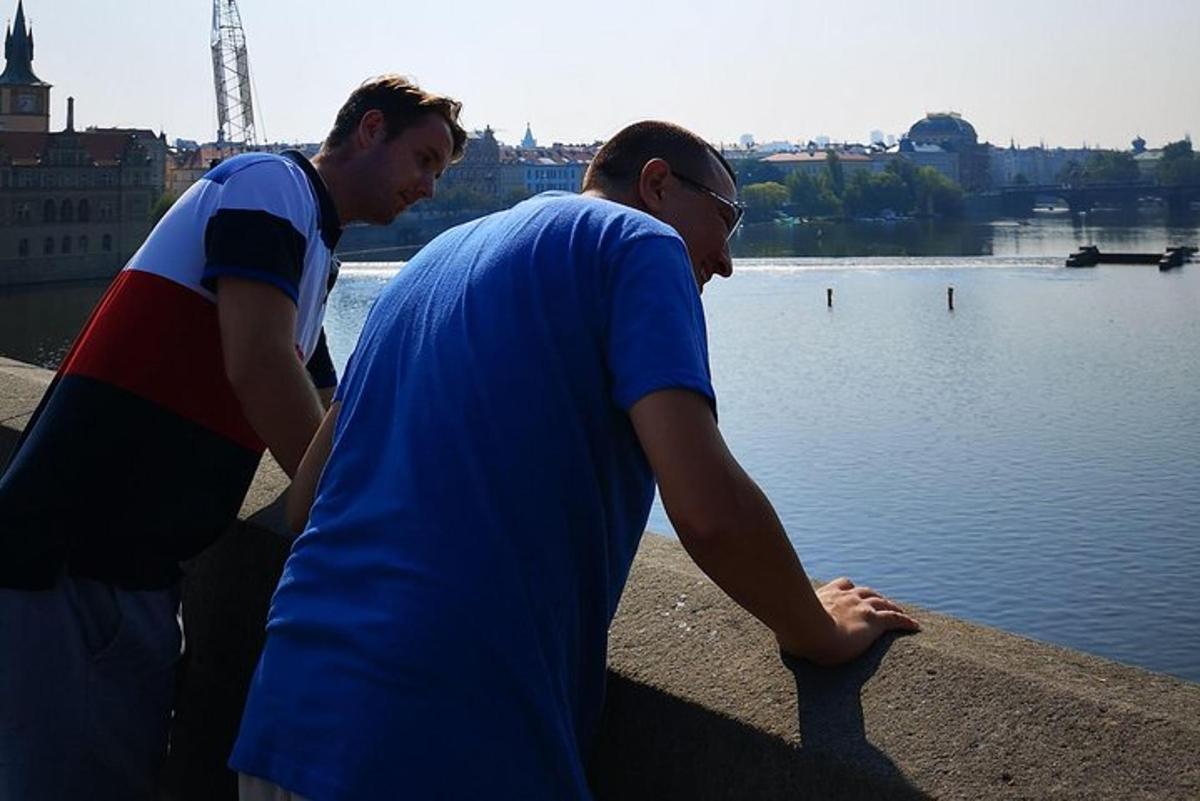 two men standing next to a body of water