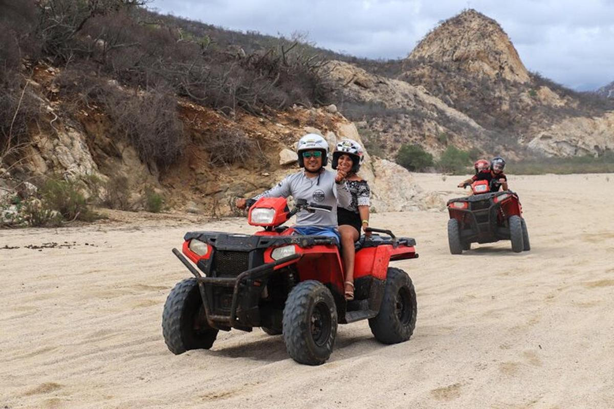 iki kişi sahilde ATV'ye biniyor