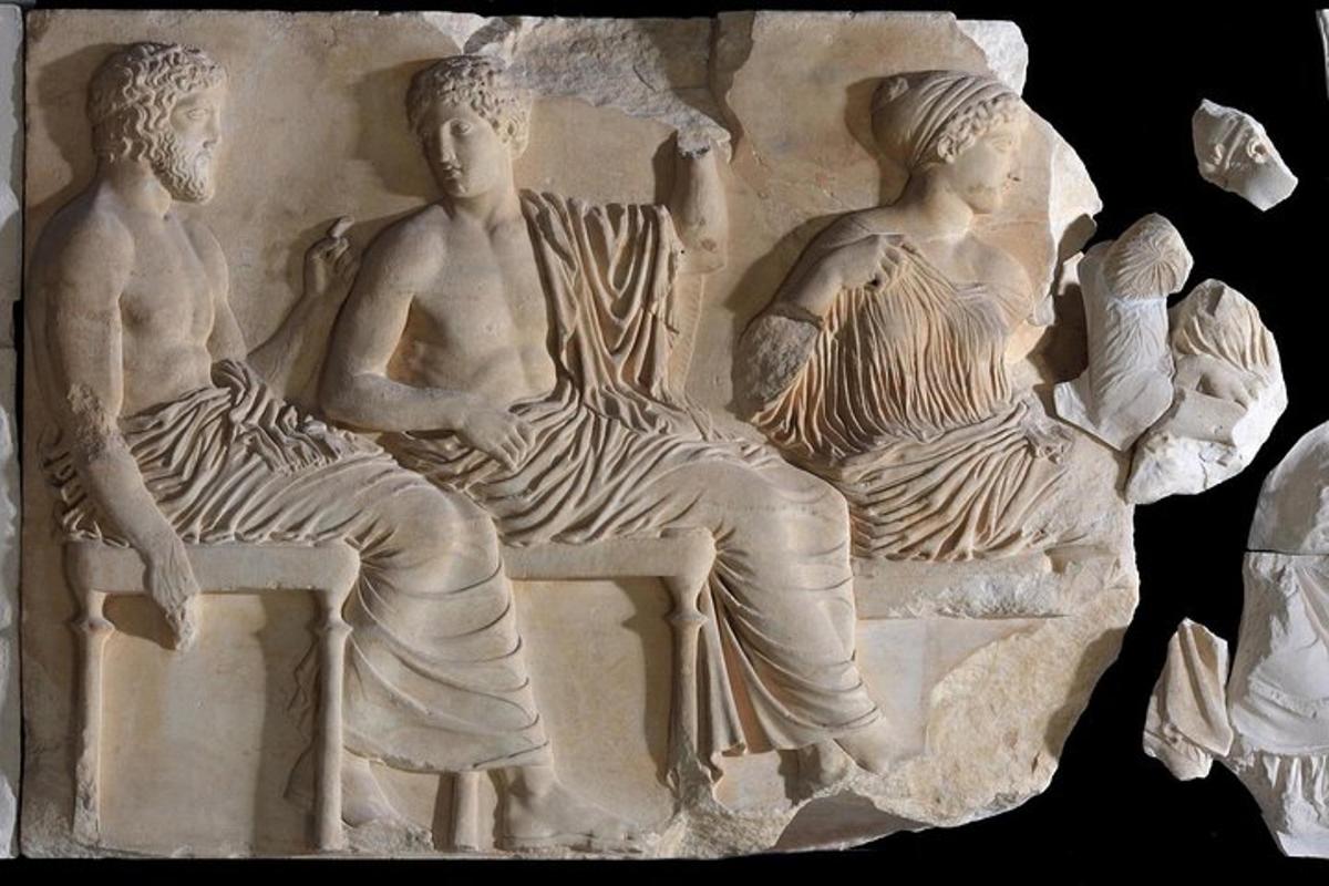 relief treh ljudi, ki sedijo na stolih