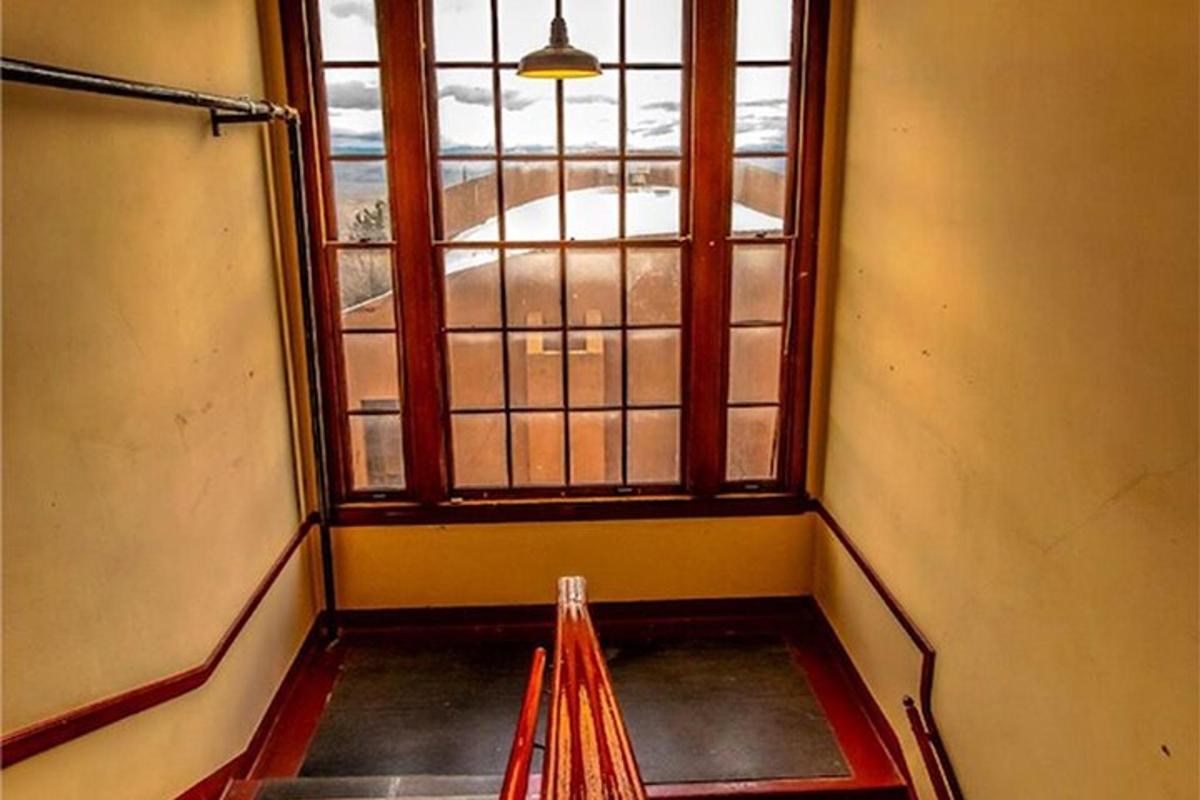 an empty room with a window and a bench