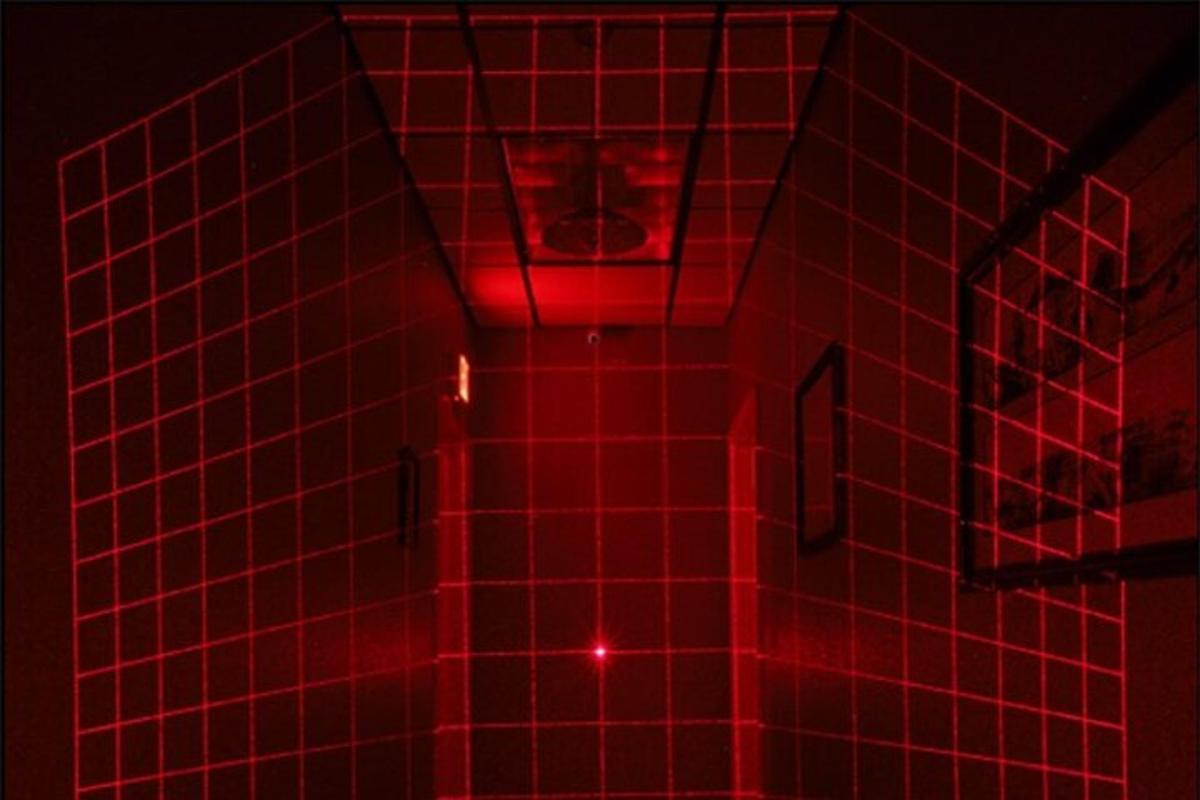 un bagno piastrellato rosso con un water illuminato da una luce rossa