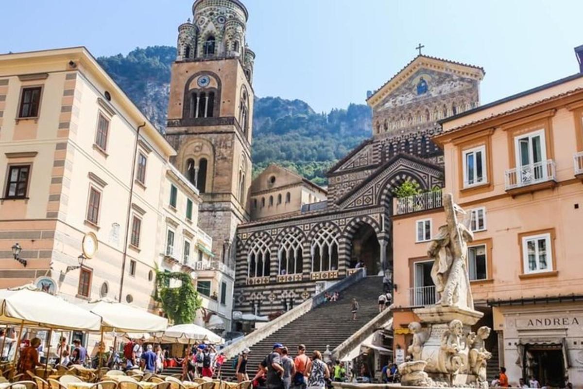 un gruppo di persone che camminano in una città con una torre dell'orologio
