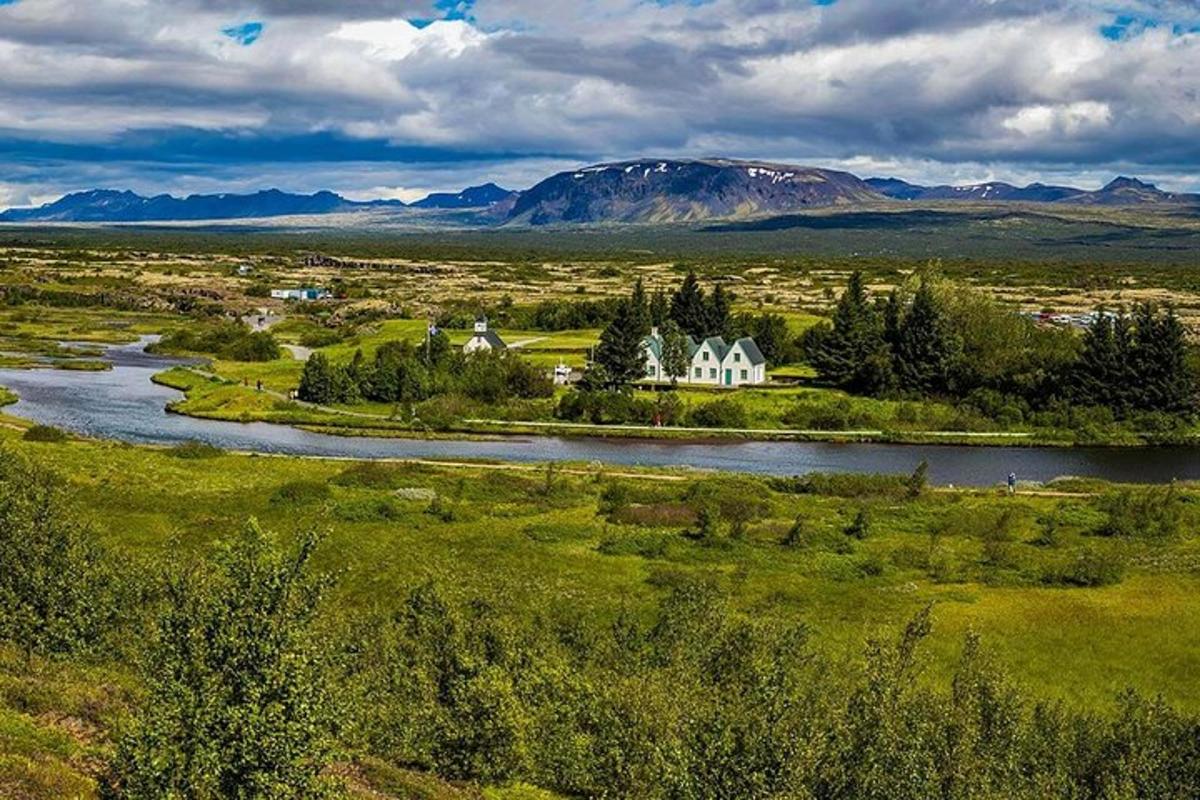 een luchtfoto van een veld met een rivier en een huis