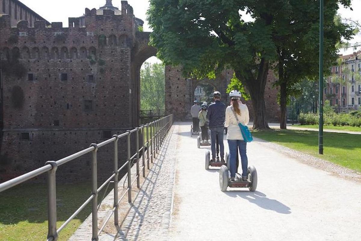 Un grupo de personas montando segways frente a un castillo.