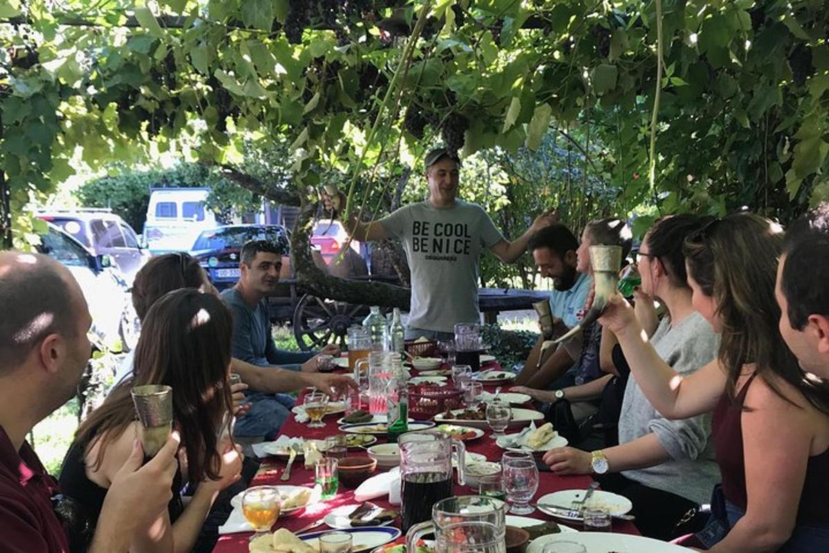 grupp inimesi istub laua ümber ja sööb