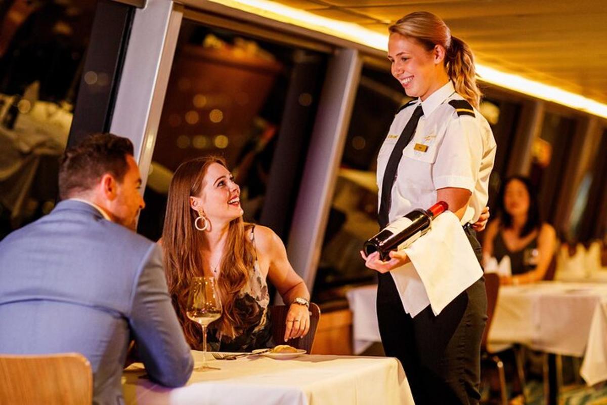a woman holding a bottle of wine next to a waiter