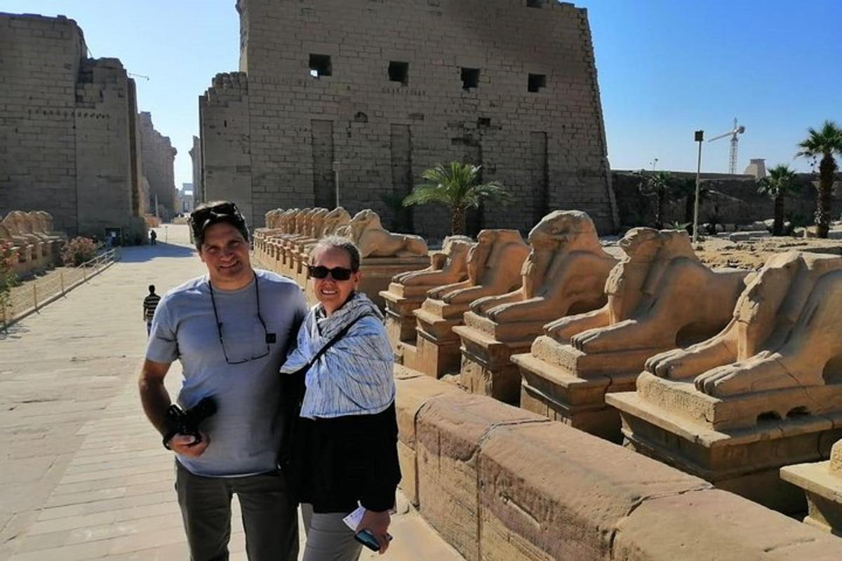 a man and a woman standing in front of some ruins
