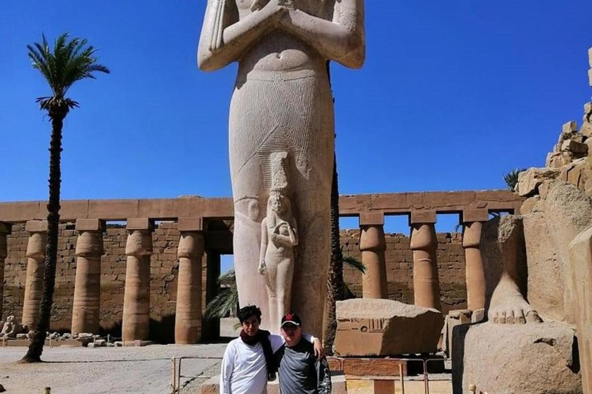 two men standing next to a statue in front of a building