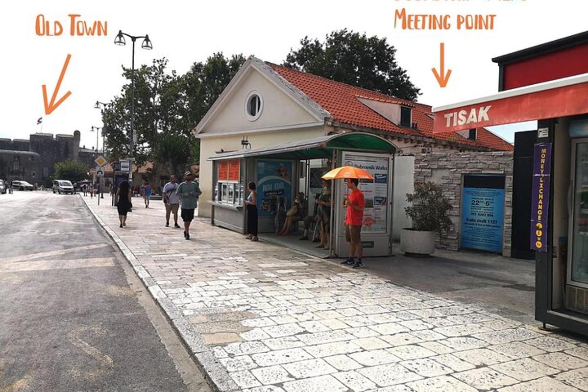 osoba s deštníkem stojící před budovou