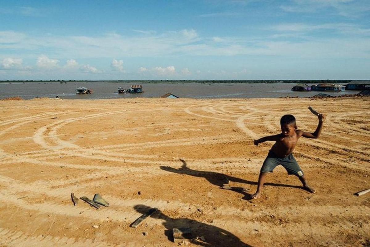 en ung gutt som leker med en frisbee på stranden