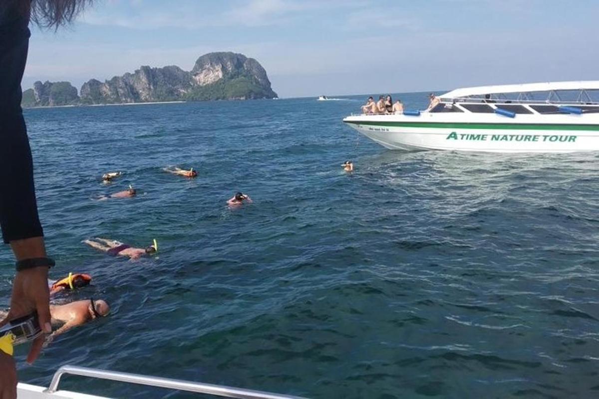 un gruppo di persone che nuotano nell'acqua accanto a una barca