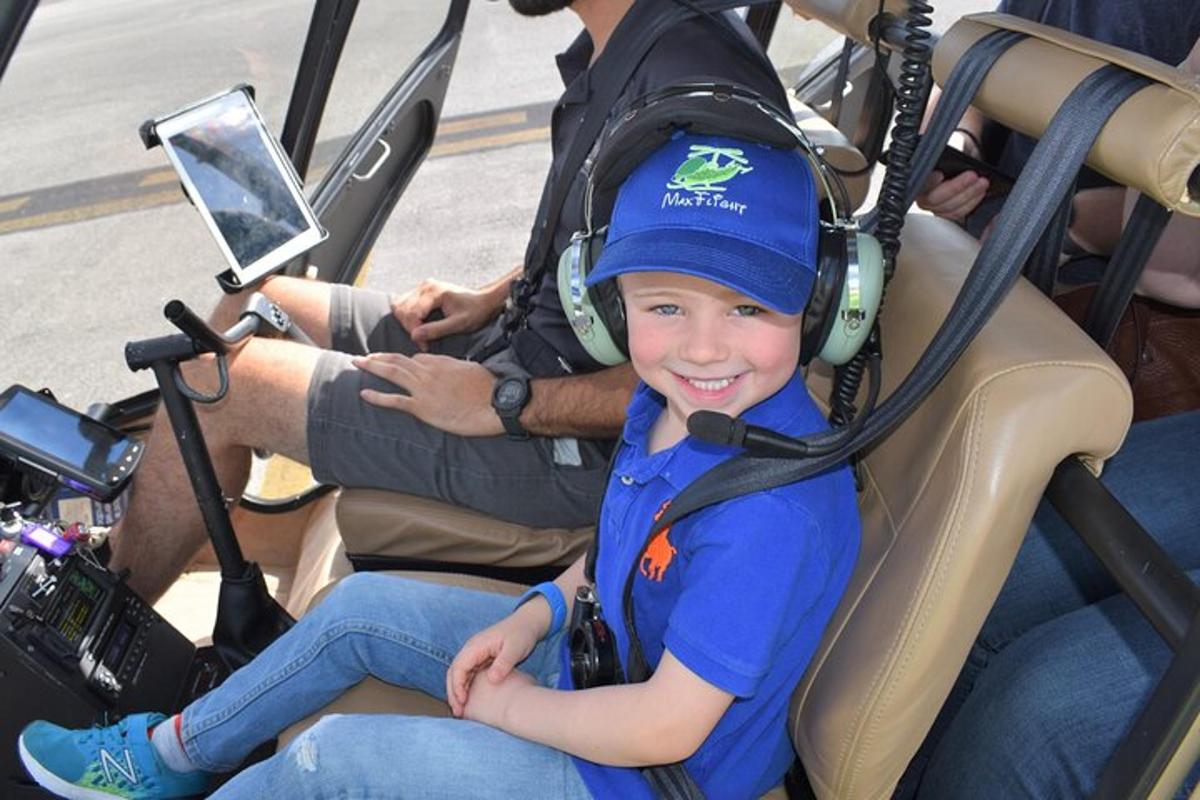 a young boy wearing headphones sitting in a helicopter
