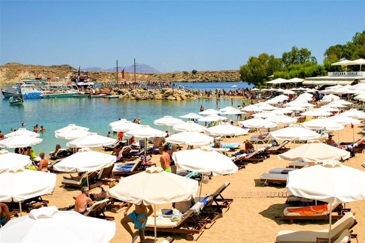 ein Strand mit vielen Stühlen und Sonnenschirmen