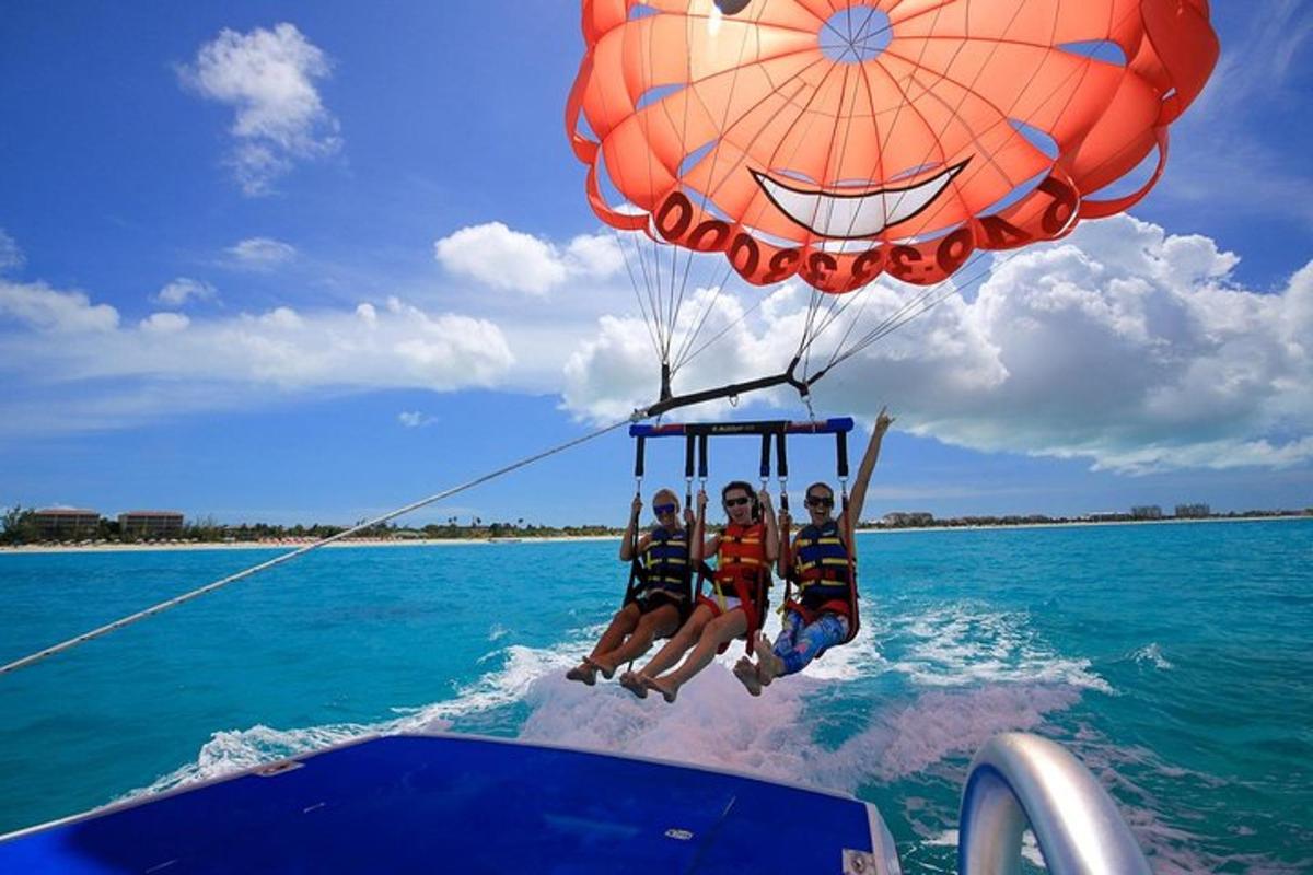 a group of people riding on a parachute in the water