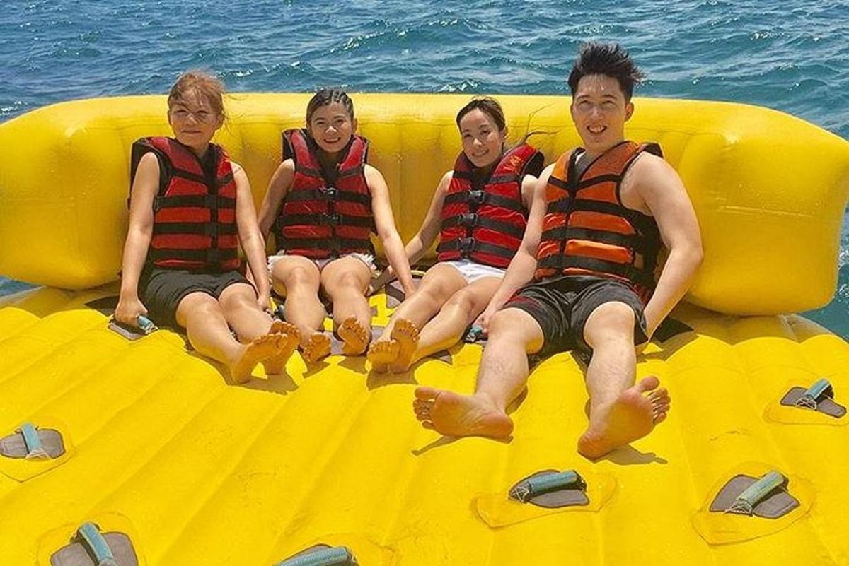 a group of boys sitting on a raft in the water