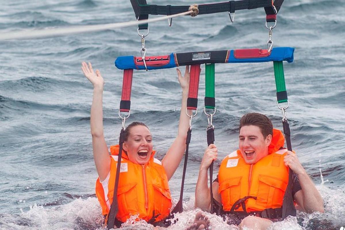 two people in orange life jackets in the water