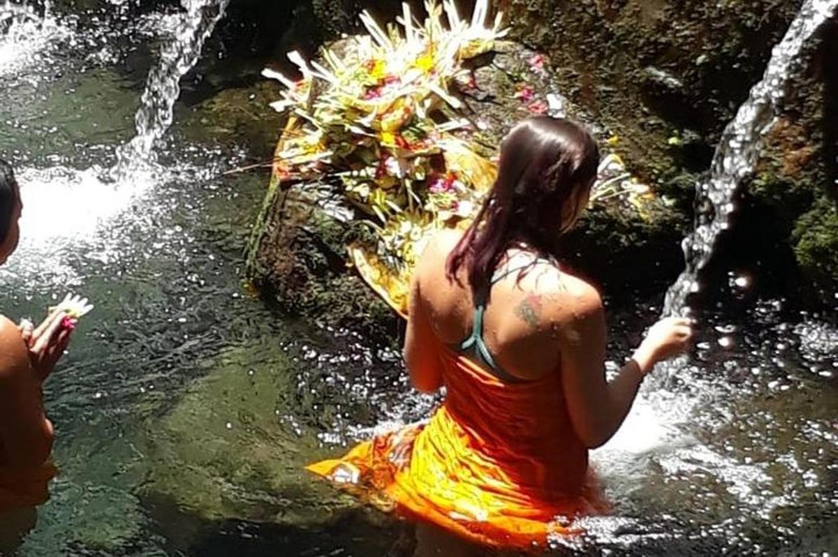 una donna in piedi nell'acqua vicino a una cascata