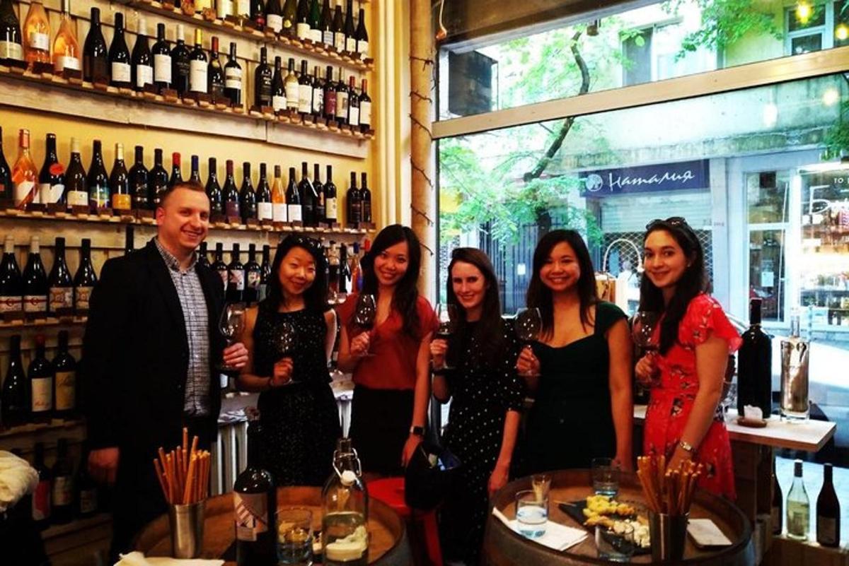 a group of people standing in a bar with wine bottles