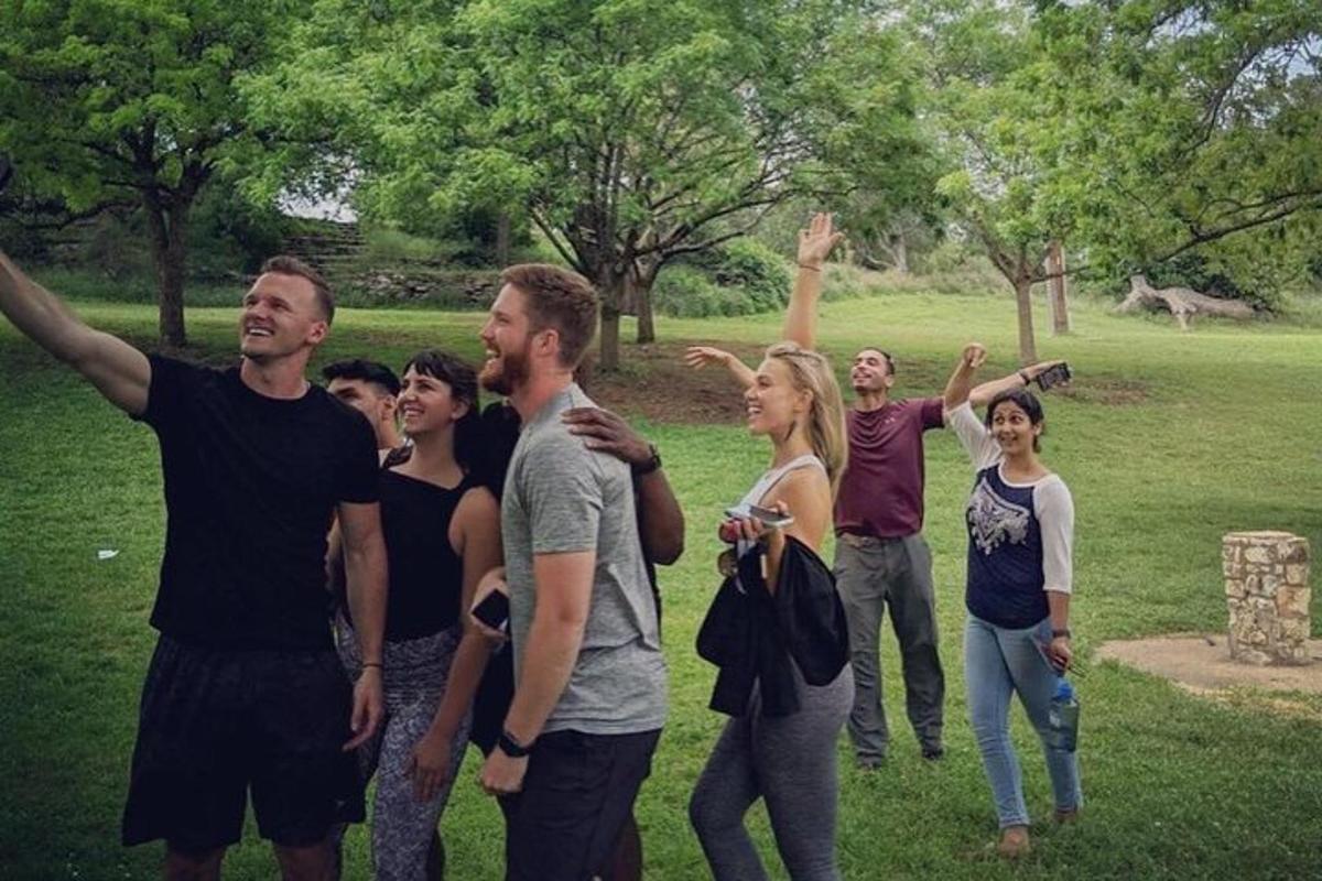 um grupo de pessoas em pé em um campo com as mãos no ar