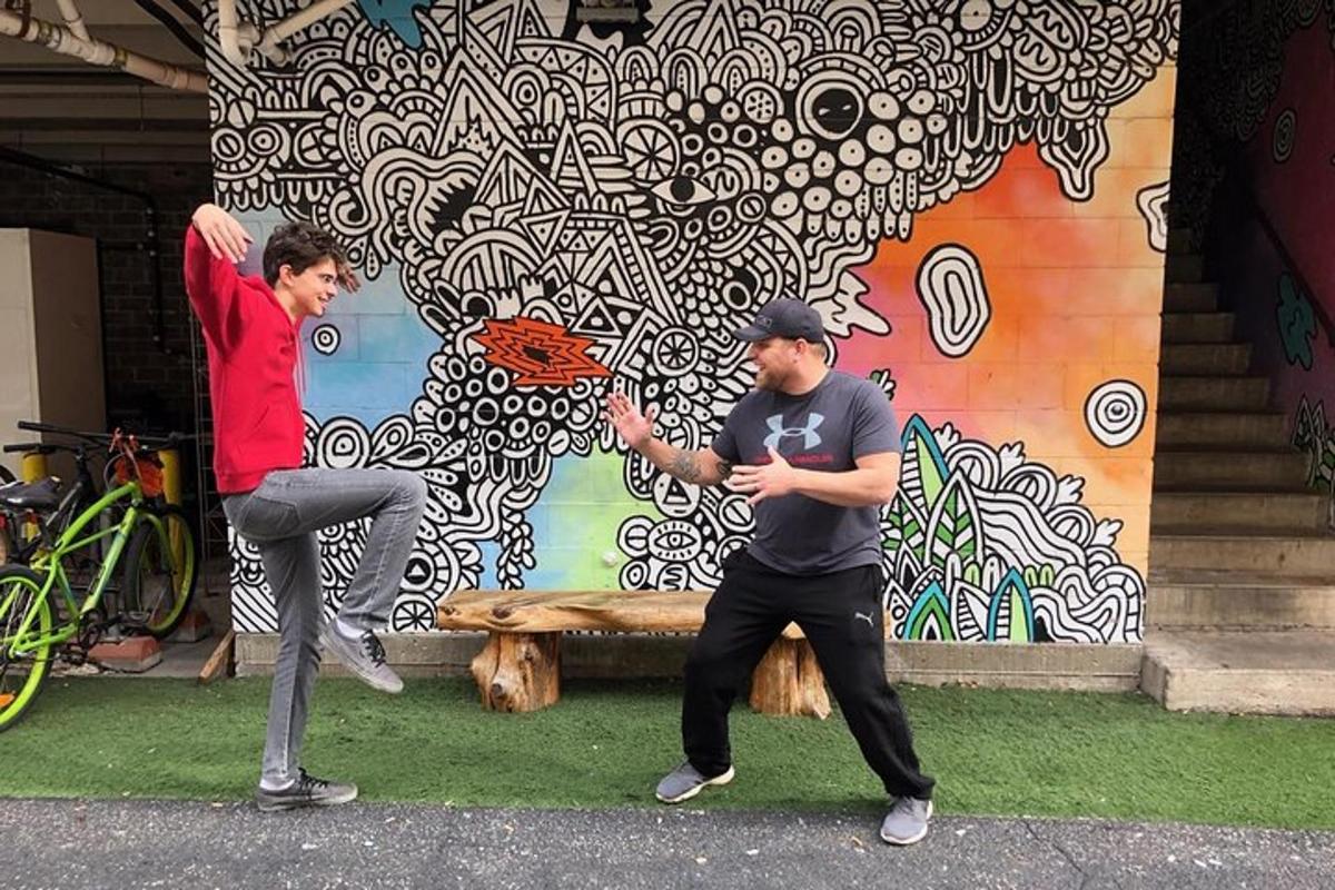 dois homens brincando com um frisbee em frente a uma parede