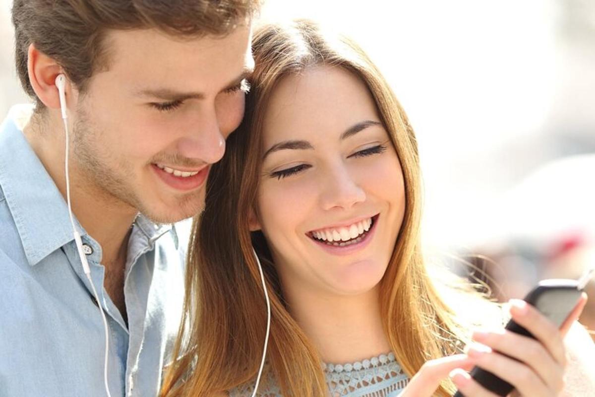 muž a žena se dívají na mobilní telefon