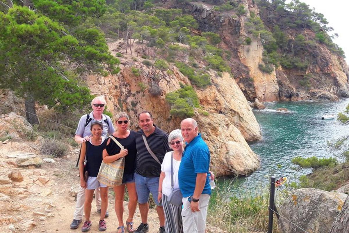 un gruppo di persone in piedi sulla riva di un fiume