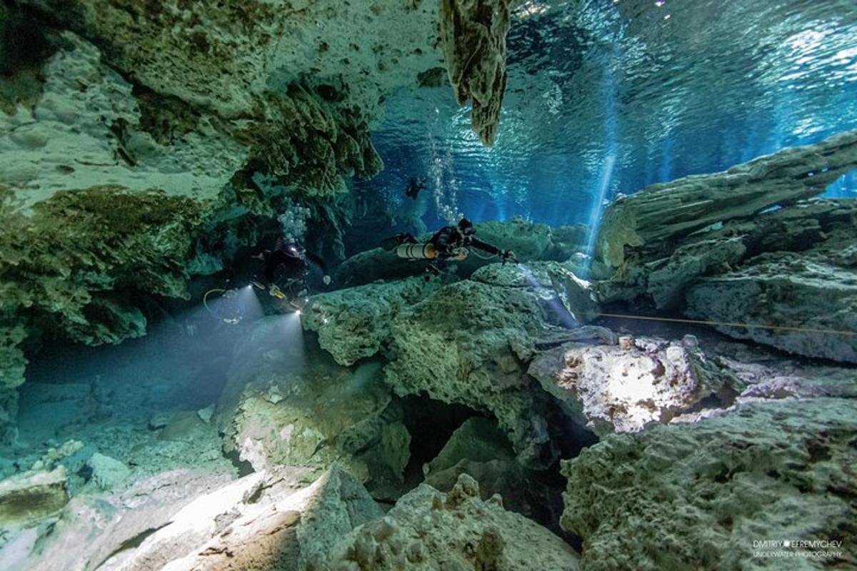 Un buceador en una cueva con rocas y agua.