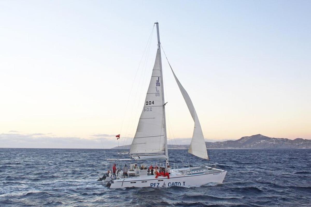 a sailboat in the ocean with people on it