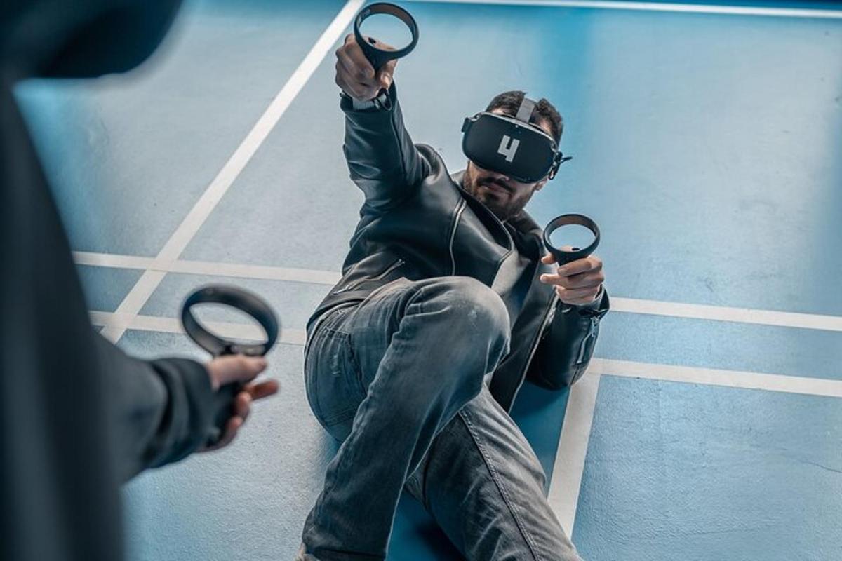 um homem usando óculos de realidade virtual segurando um par de fones de ouvido