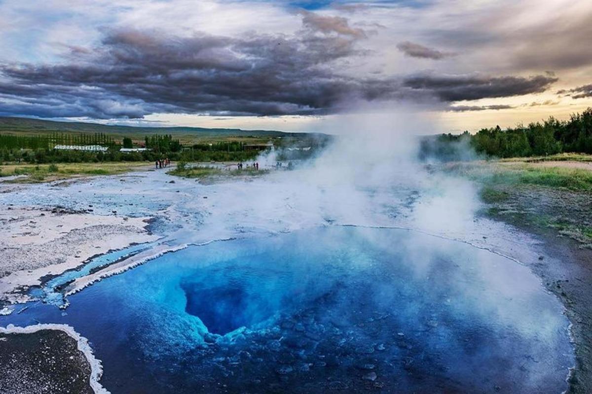 uma imagem de um gêiser com água azul e vapor